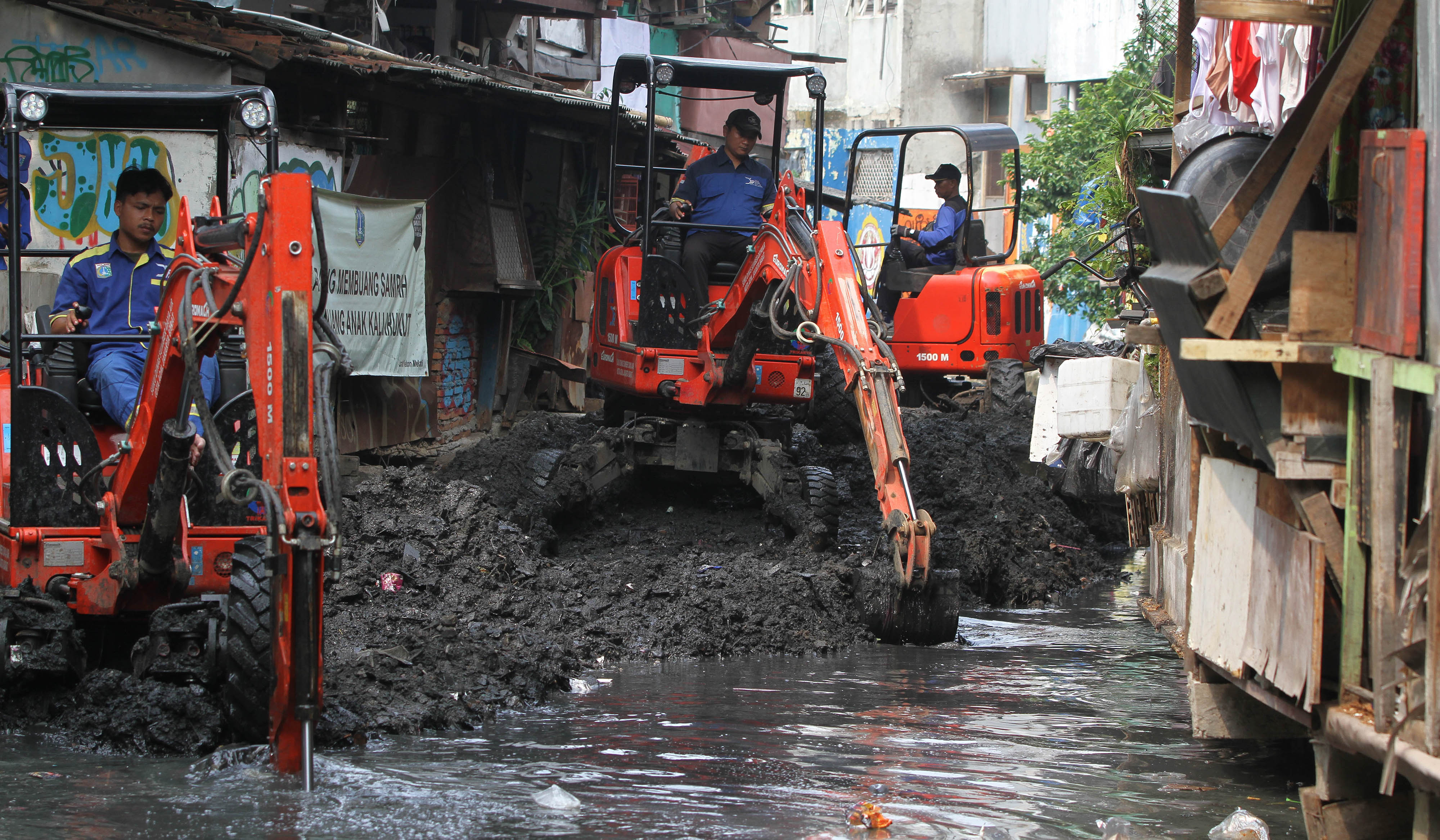 Petugas keruk lumpur kali Krukut. (Agus Priatna/SinPo.id)