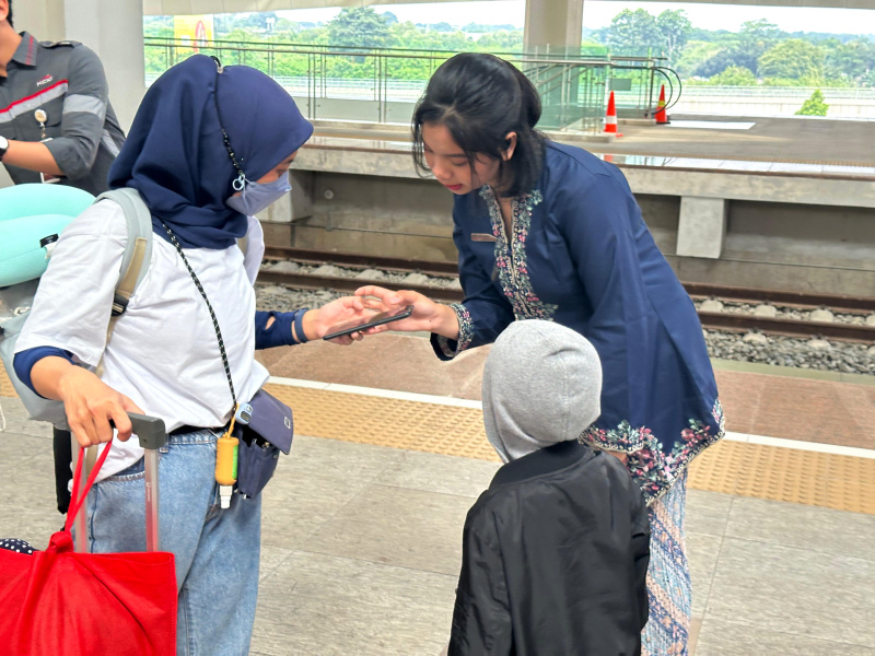 Petugas Passenger Service KCIC membagikan 150 bunga pada penumpang perempuan di Hari Kartini di Stasiun Halim KCIC (Ashar/SinPo.id)