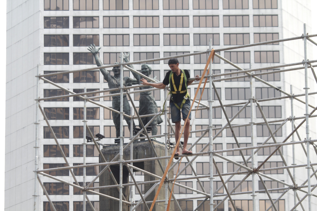 Para pekerja sedang menyelesaikan pembuatan panggung untuk penyambutan perayaan malam tahun baru (Ashar/SinPo.id)