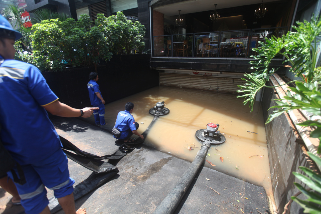 Petugas Dinas Sumber Daya Air (SDA) sedang melakukan penyedotan sisa banjir di basement gedung kemang (Ashar/SinPo.id)SinPo.id)