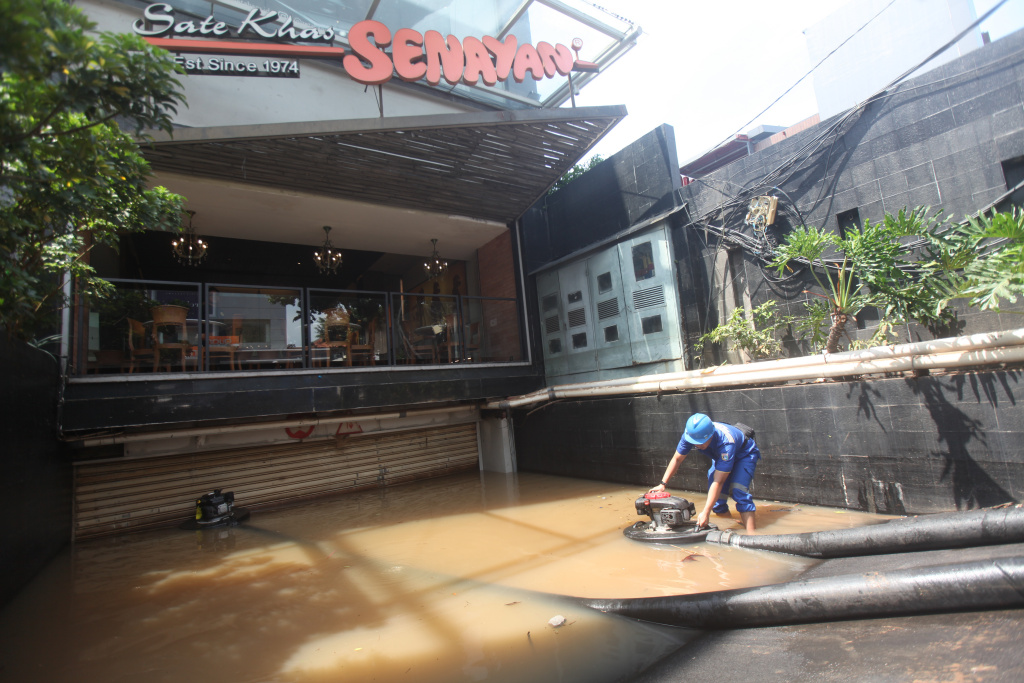 Petugas Dinas Sumber Daya Air (SDA) sedang melakukan penyedotan sisa banjir di basement gedung kemang (Ashar/SinPo.id)SinPo.id)