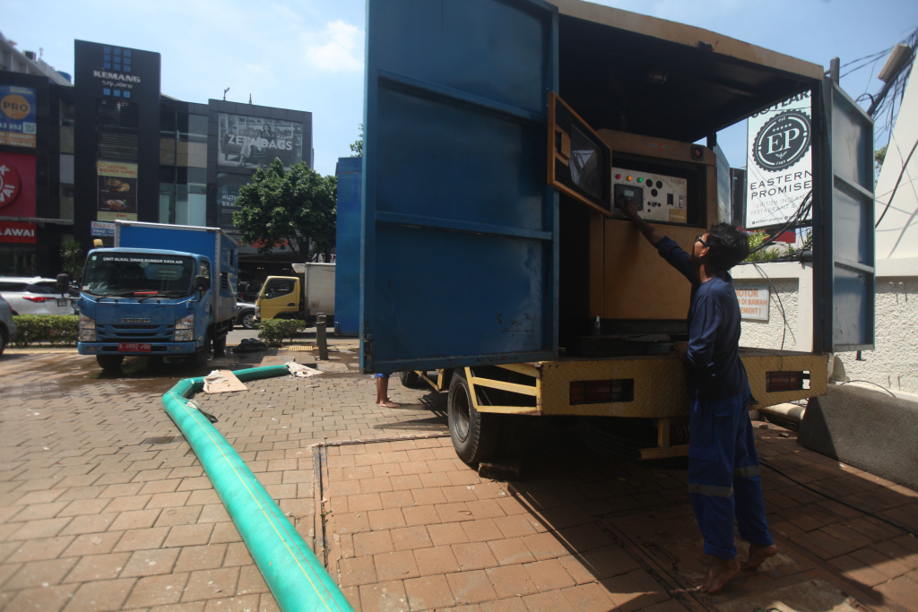 Petugas Dinas Sumber Daya Air (SDA) sedang melakukan penyedotan sisa banjir di basement gedung kemang (Ashar/SinPo.id)SinPo.id)
