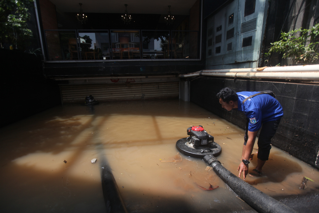 Petugas Dinas Sumber Daya Air (SDA) sedang melakukan penyedotan sisa banjir di basement gedung kemang (Ashar/SinPo.id)SinPo.id)
