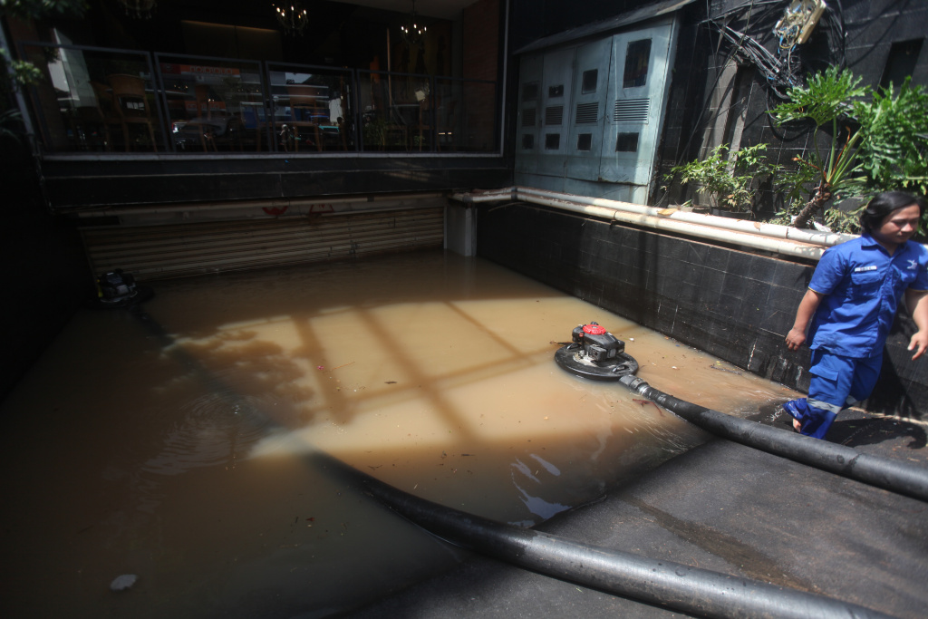 Petugas Dinas Sumber Daya Air (SDA) sedang melakukan penyedotan sisa banjir di basement gedung kemang (Ashar/SinPo.id)SinPo.id)
