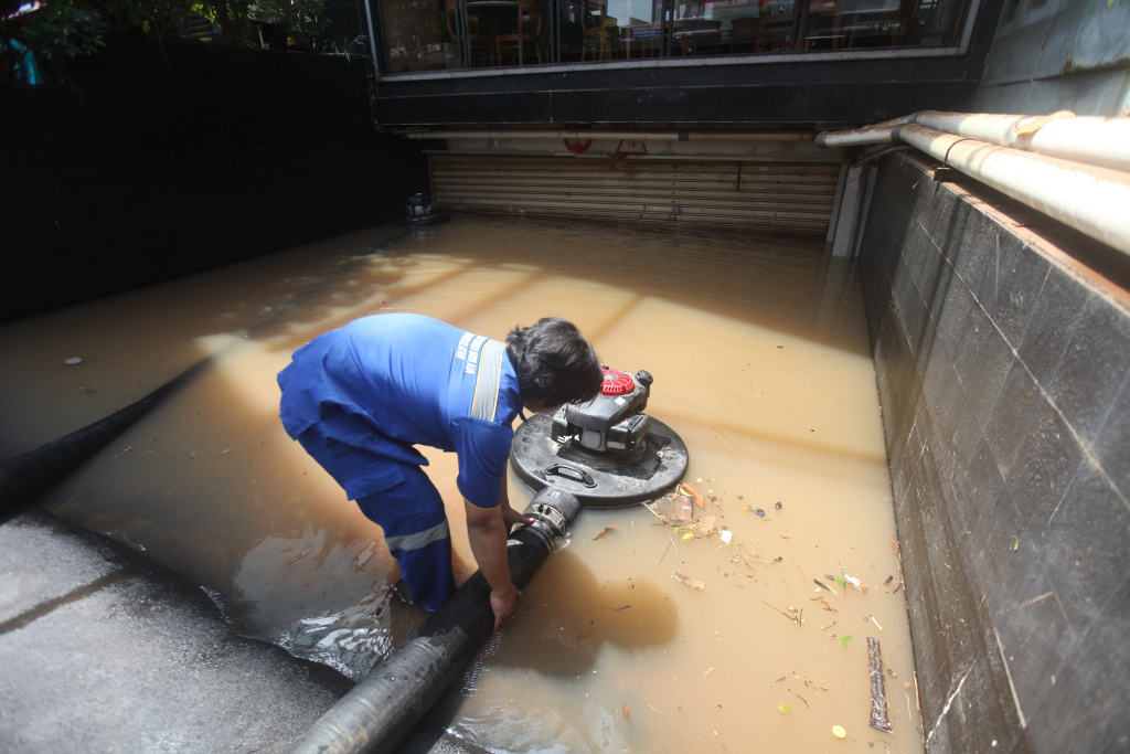 Petugas Dinas Sumber Daya Air (SDA) sedang melakukan penyedotan sisa banjir di basement gedung kemang (Ashar/SinPo.id)SinPo.id)