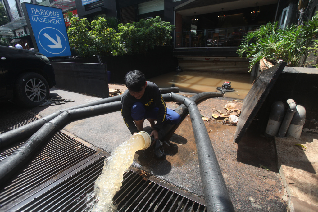 Petugas Dinas Sumber Daya Air (SDA) sedang melakukan penyedotan sisa banjir di basement gedung kemang (Ashar/SinPo.id)SinPo.id)