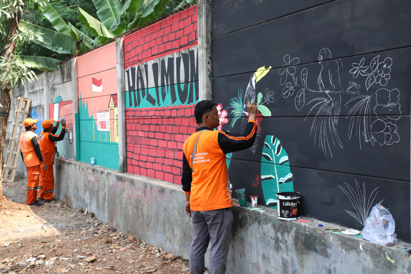 Petugas PPSU Guntur Jakarta Selatan membuat mural untuk menyambut Hari Kemerdekaan Republik Indonesia ke-79 (Ashar/SinPo.id)