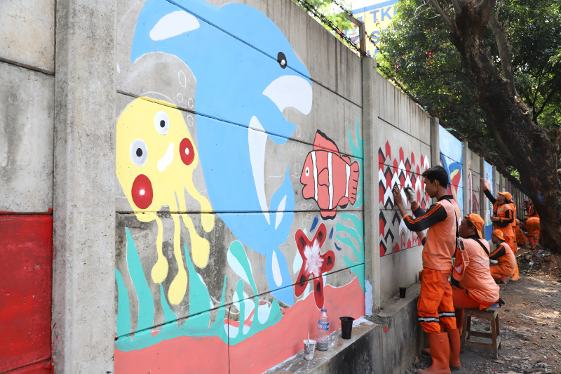 Petugas PPSU Guntur Jakarta Selatan membuat mural untuk menyambut Hari Kemerdekaan Republik Indonesia ke-79 (Ashar/SinPo.id)