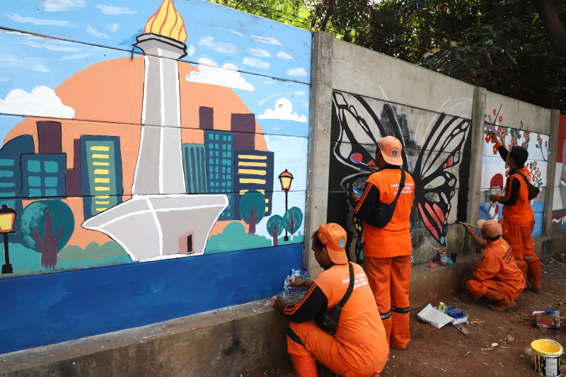 Petugas PPSU Guntur Jakarta Selatan membuat mural untuk menyambut Hari Kemerdekaan Republik Indonesia ke-79 (Ashar/SinPo.id)