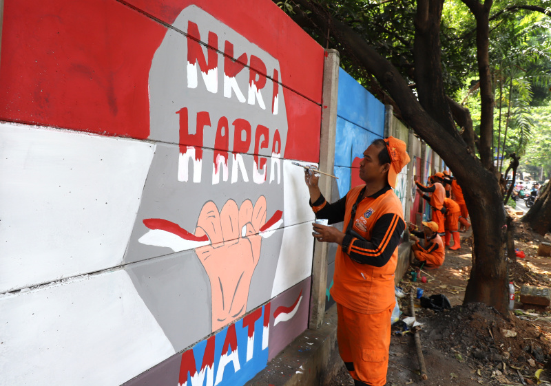 Petugas PPSU Guntur Jakarta Selatan membuat mural untuk menyambut Hari Kemerdekaan Republik Indonesia ke-79 (Ashar/SinPo.id)