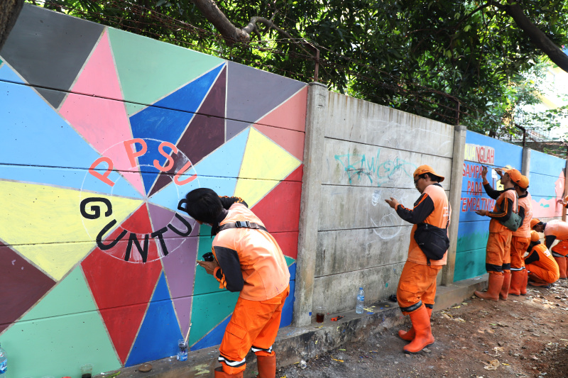 Petugas PPSU Guntur Jakarta Selatan membuat mural untuk menyambut Hari Kemerdekaan Republik Indonesia ke-79 (Ashar/SinPo.id)