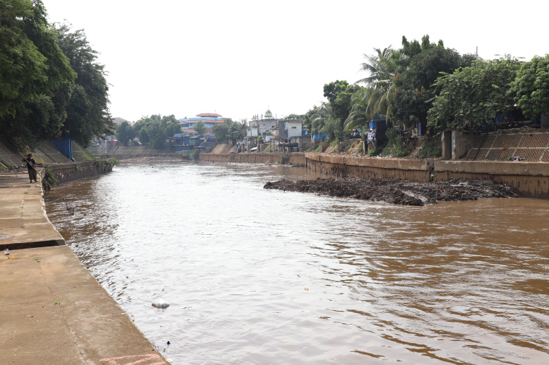 Petugas Dinas Sumber Daya Air Jakarta sedang melakukan pengerukan lumpur menggunakan alat berat ekskavator untuk mencegah terjadinya banjir ketika musim hujan datang (Ashar/SinPo.id)