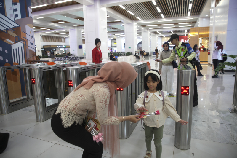 Petugas Kereta Cepat Whoosh sedang membagikan bunga untuk para penumpang whoosh dalam memperingati Hari Kartini (Ashar/SinPo.id)