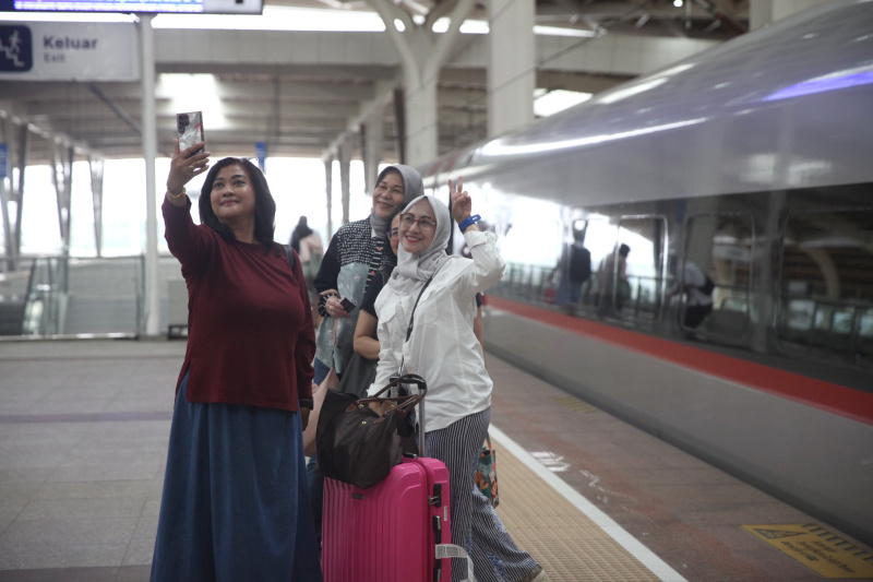 Petugas Kereta Cepat Whoosh sedang membagikan bunga untuk para penumpang whoosh dalam memperingati Hari Kartini (Ashar/SinPo.id)