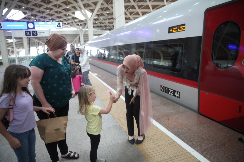 Petugas Kereta Cepat Whoosh sedang membagikan bunga untuk para penumpang whoosh dalam memperingati Hari Kartini (Ashar/SinPo.id)