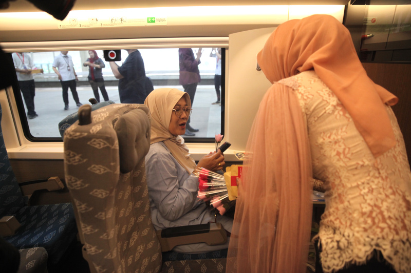 Petugas Kereta Cepat Whoosh sedang membagikan bunga untuk para penumpang whoosh dalam memperingati Hari Kartini (Ashar/SinPo.id)