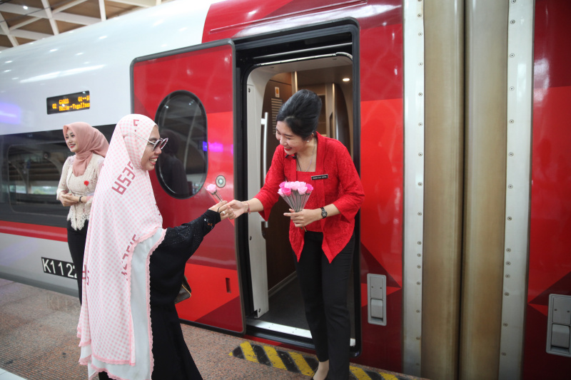 Petugas Kereta Cepat Whoosh sedang membagikan bunga untuk para penumpang whoosh dalam memperingati Hari Kartini (Ashar/SinPo.id)