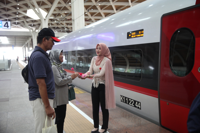 Petugas Kereta Cepat Whoosh sedang membagikan bunga untuk para penumpang whoosh dalam memperingati Hari Kartini (Ashar/SinPo.id)