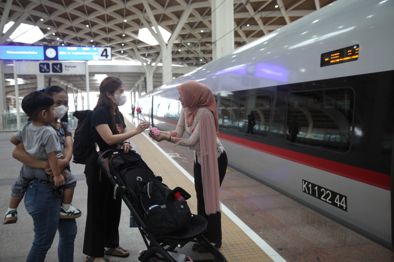 Petugas Kereta Cepat Whoosh sedang membagikan bunga untuk para penumpang whoosh dalam memperingati Hari Kartini (Ashar/SinPo.id)