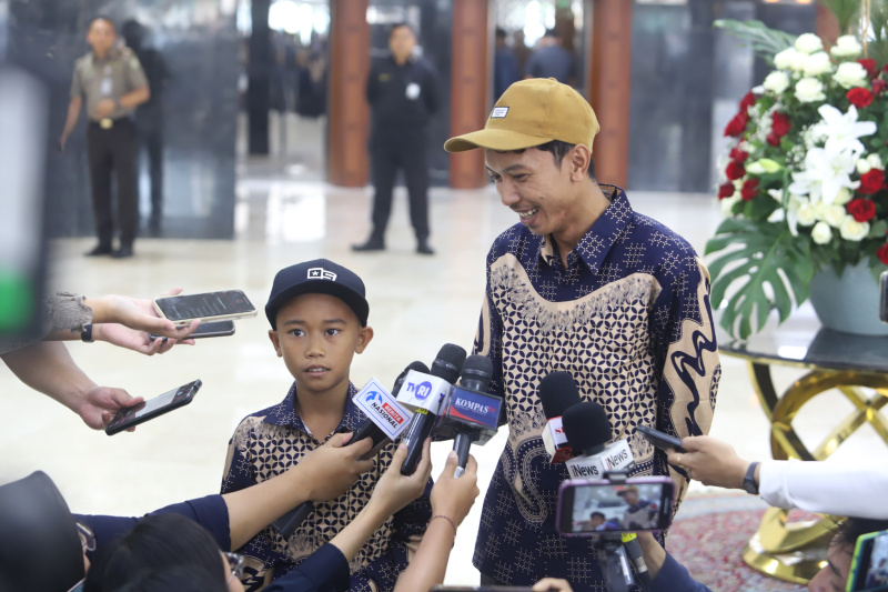 Wakil Ketua DPR Prof Sufmi Dasco Ahmad berikan apresiasi hadiah pendidikan khusus untuk Siswa SD Negeri 1 Raihan Diaz Rinawi saat membetulkan tali bendera tersangkut (Ashar/SinPo.id)