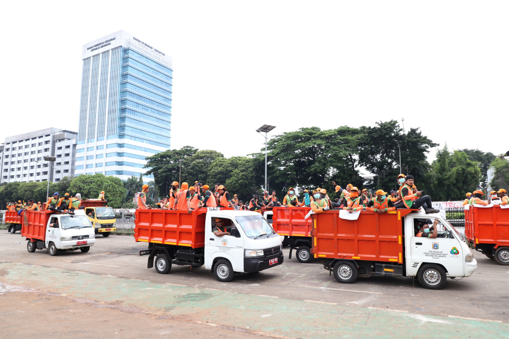 Petugas PPSU dan Dinas Bina Marga Provinsi DKI Jakarta sedang membersihkan jalan dan coretan vandalisme di tembok gedung DPR (Ashar/SinPo.id)