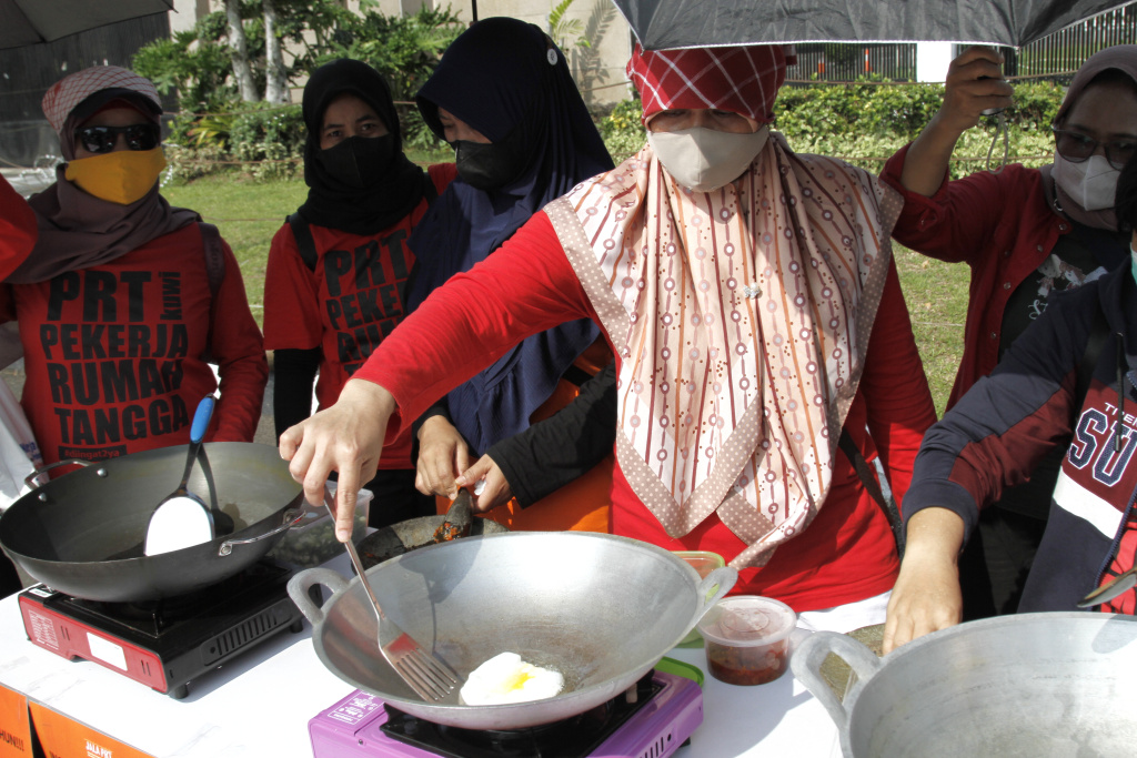 Massa dari Koalisi sipil pekerja rumah tangga  gelar demo teatrikal memasak sarapan nasi goreng di depan Gedung DPR RI (Ashar/SinPo.id)