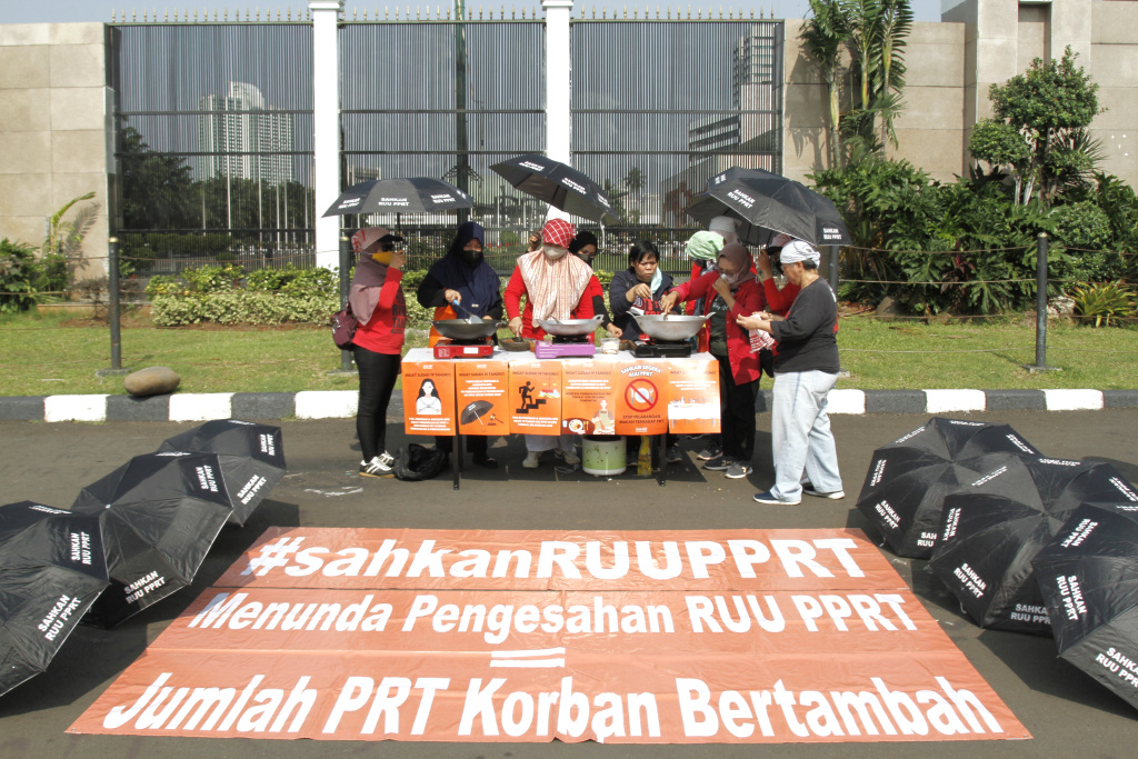 Massa dari Koalisi sipil pekerja rumah tangga  gelar demo teatrikal memasak sarapan nasi goreng di depan Gedung DPR RI (Ashar/SinPo.id)