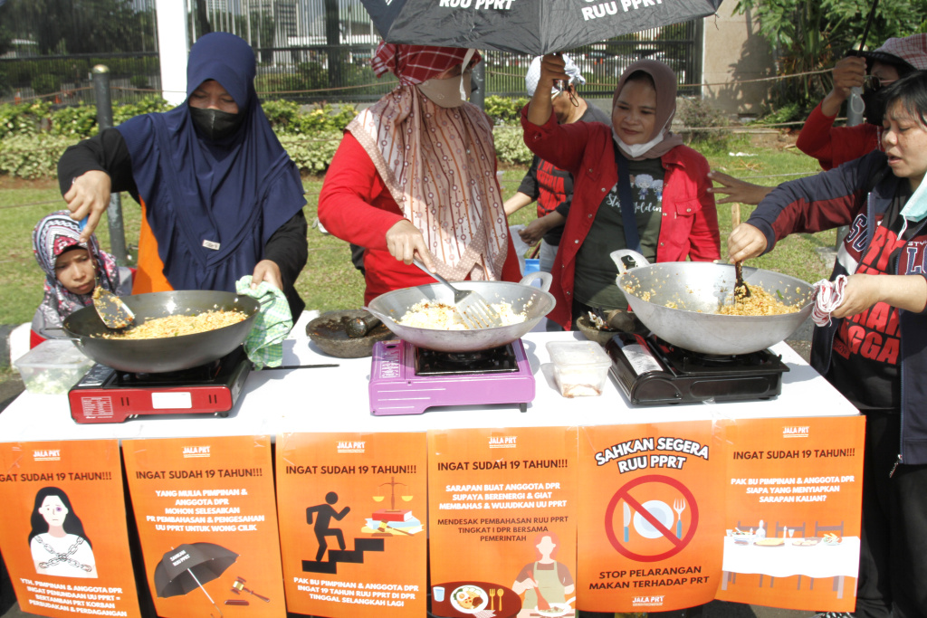 Massa dari Koalisi sipil pekerja rumah tangga  gelar demo teatrikal memasak sarapan nasi goreng di depan Gedung DPR RI (Ashar/SinPo.id)