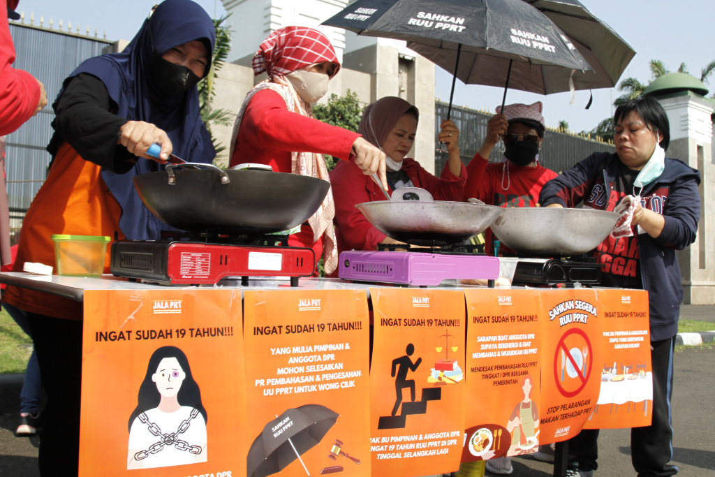 Massa dari Koalisi sipil pekerja rumah tangga  gelar demo teatrikal memasak sarapan nasi goreng di depan Gedung DPR RI (Ashar/SinPo.id)