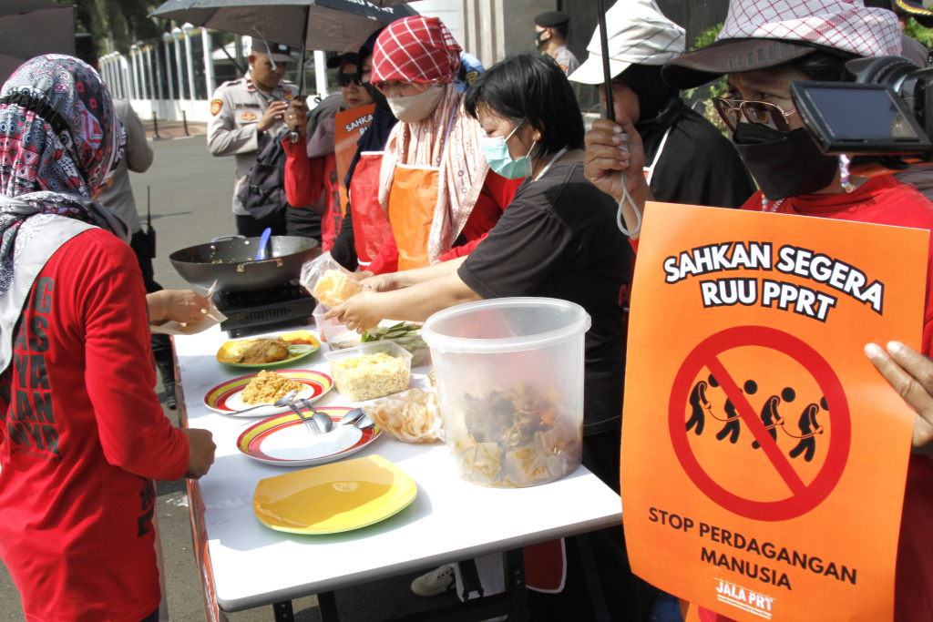 Massa dari Koalisi sipil pekerja rumah tangga  gelar demo teatrikal memasak sarapan nasi goreng di depan Gedung DPR RI (Ashar/SinPo.id)