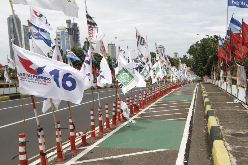 Sejumlah alat peraga kampanye melanggar peraturan pemerintah memasang di pembatas jalur sepeda (Ashar/SinPo.id)
