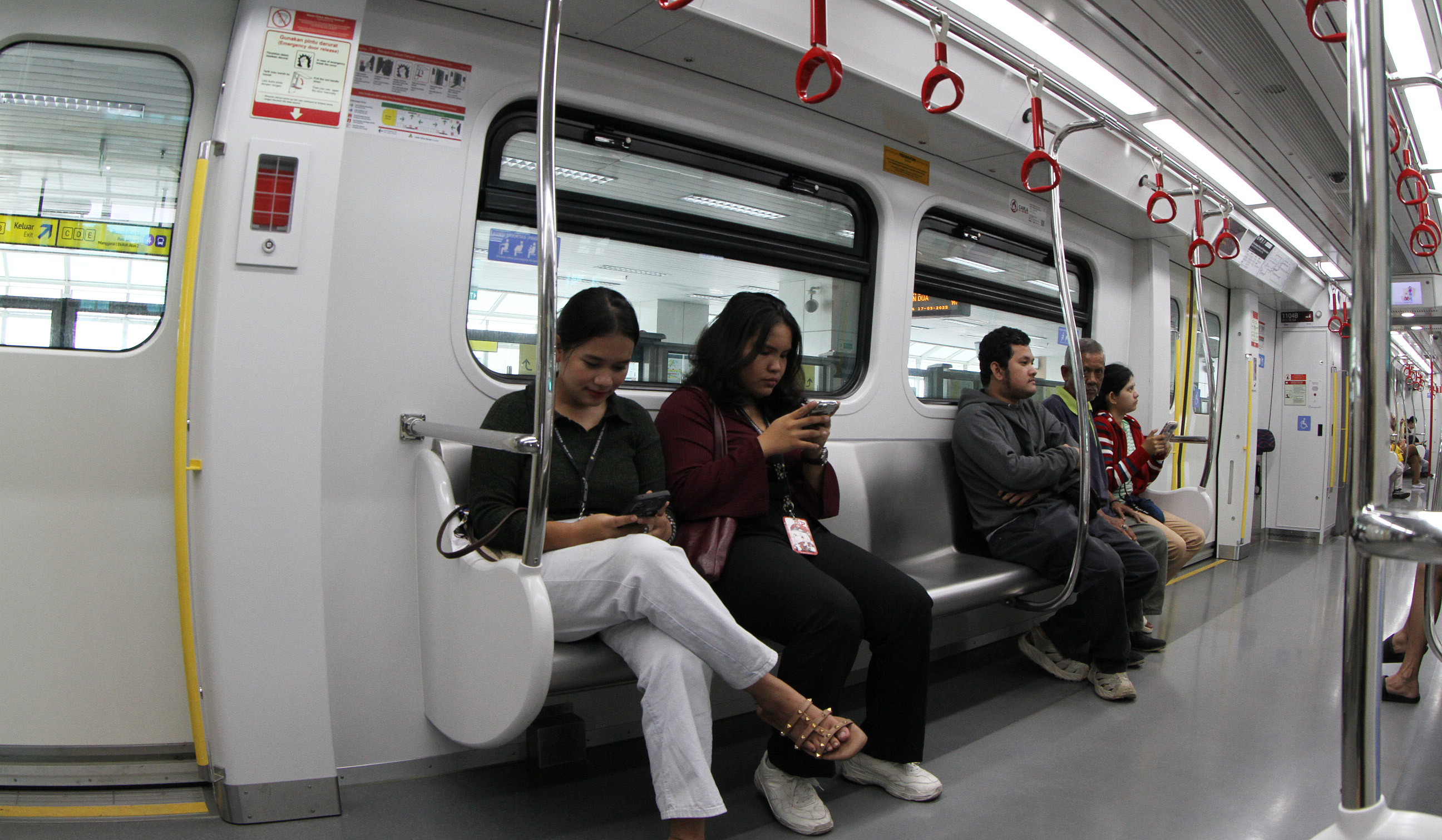 Penumpang saat berada didalam gerbong LRT Jakarta. (Agus Priatna/SinPo.id)
