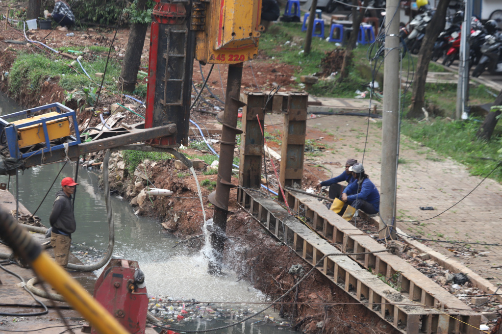 Pekerja sedang memasang rangka besi pada proyek pembangunan dinding turap Kali Cideng Atas, Jalan Rasuna Said (Ashar/SinPo.id)