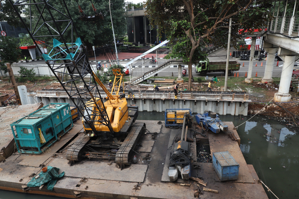 Pekerja sedang memasang rangka besi pada proyek pembangunan dinding turap Kali Cideng Atas, Jalan Rasuna Said (Ashar/SinPo.id)