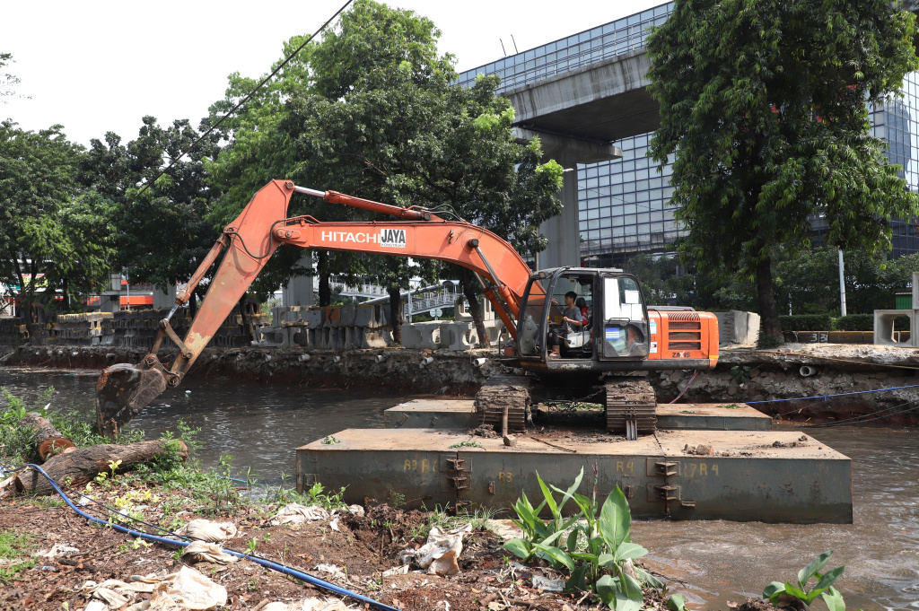 Pekerja sedang melakukan pengerukan lumpur di proyek revitalisasi kali Cideng (Ashar/SinPo.id)