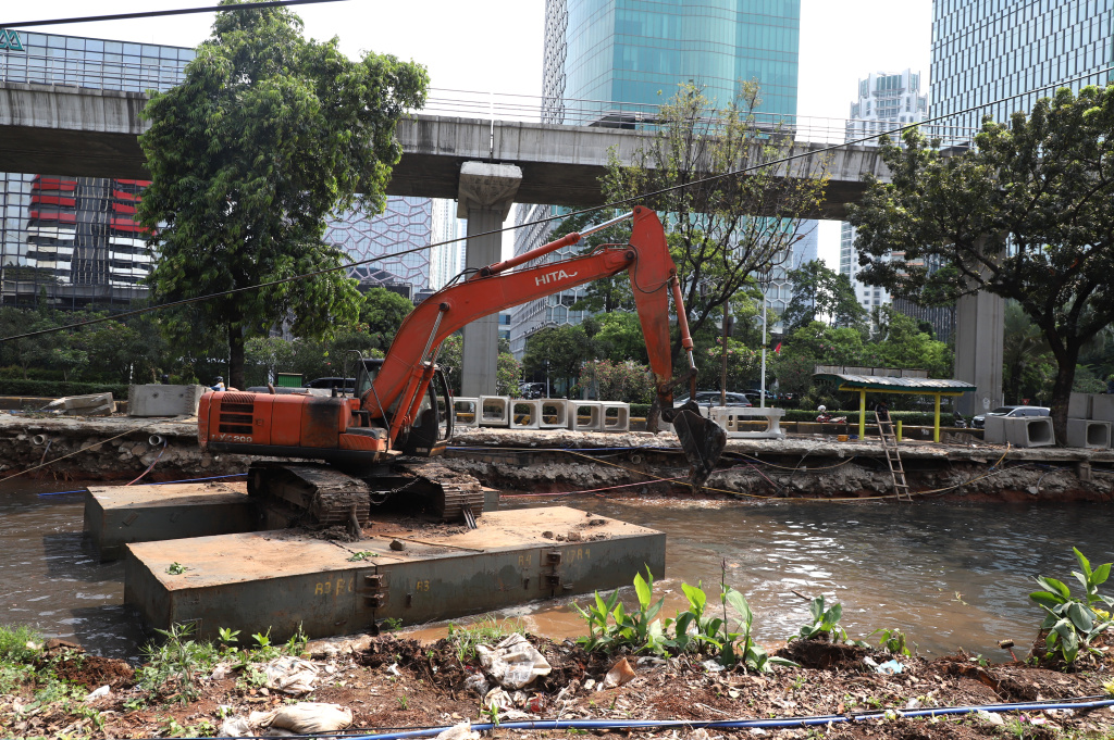 Pekerja sedang melakukan pengerukan lumpur di proyek revitalisasi kali Cideng (Ashar/SinPo.id)