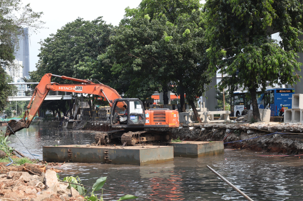 Pekerja sedang melakukan pengerukan lumpur di proyek revitalisasi kali Cideng (Ashar/SinPo.id)