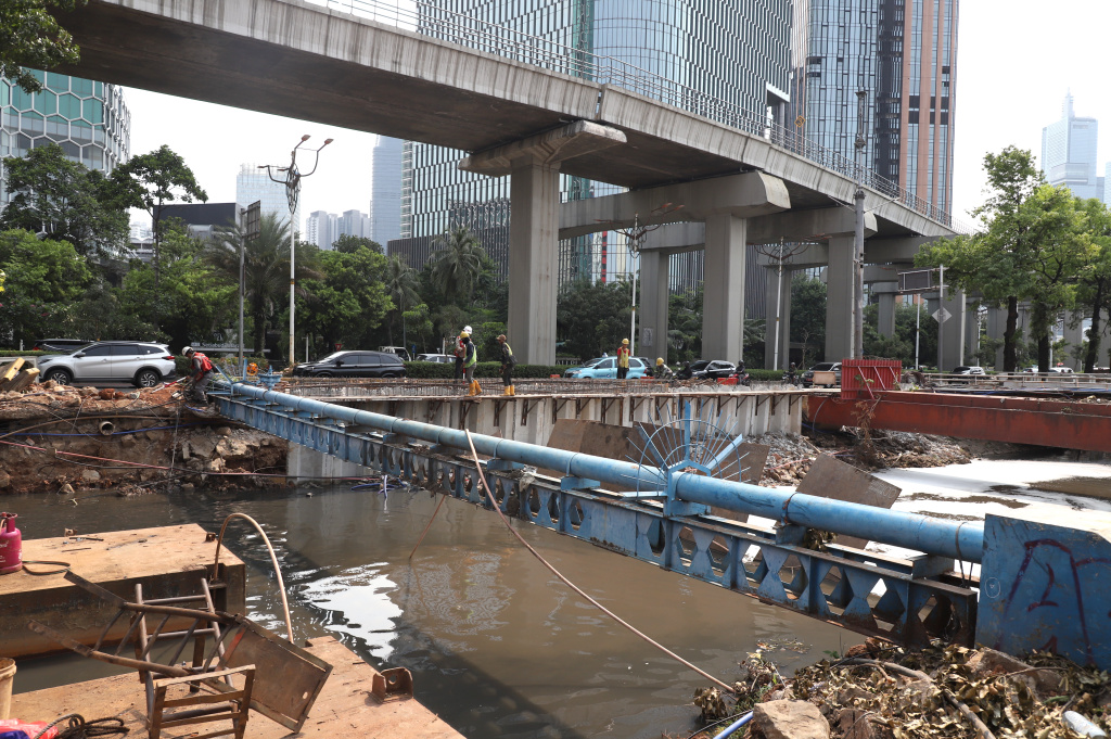 Pekerja sedang melakukan pengerukan lumpur di proyek revitalisasi kali Cideng (Ashar/SinPo.id)
