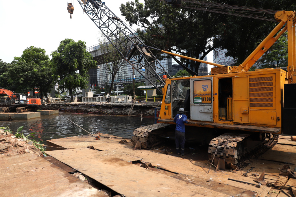 Pekerja sedang melakukan pengerukan lumpur di proyek revitalisasi kali Cideng (Ashar/SinPo.id)