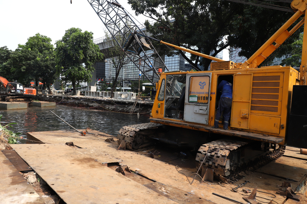 Pekerja sedang melakukan pengerukan lumpur di proyek revitalisasi kali Cideng (Ashar/SinPo.id)