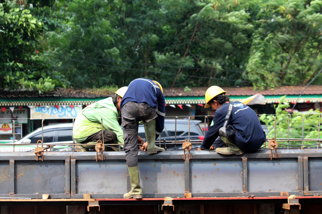 Pekerja sedang melakukan pengerukan lumpur di proyek revitalisasi kali Cideng (Ashar/SinPo.id)