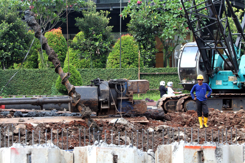 Pekerja sedang melakukan pengerukan lumpur di proyek revitalisasi kali Cideng (Ashar/SinPo.id)