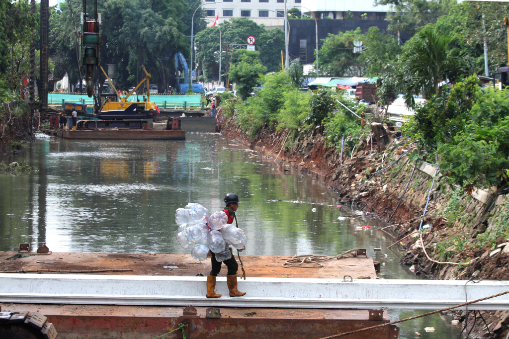 Pekerja sedang melakukan pengerukan lumpur di proyek revitalisasi kali Cideng (Ashar/SinPo.id)