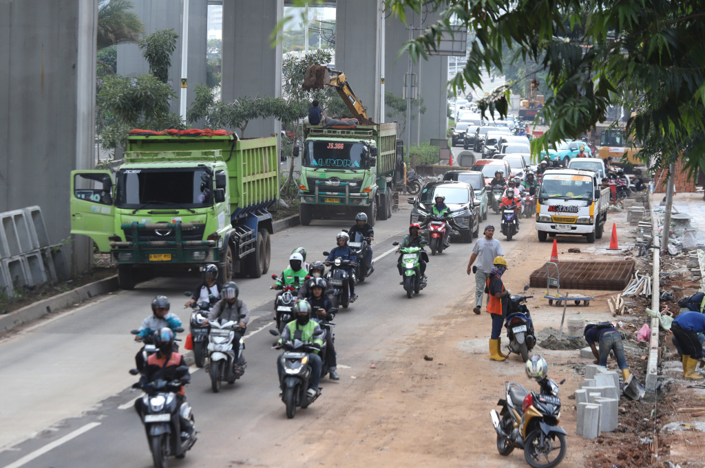 Pekerja sedang memasang rangka besi untuk trotoar di Rasuna Said (Ashar/SinPo.id)