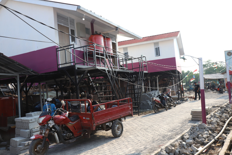 Pekerja sedang menyelesaikan rumah apung dan rumah panggung program dari Kementerian Pertahanan bekerja sama dengan Unhan untuk warga pesisir Muara Angke, Penjaringan untuk mengatasi sering terjadinya abrasi dan banjir rob (Ashar/SinPo.id)