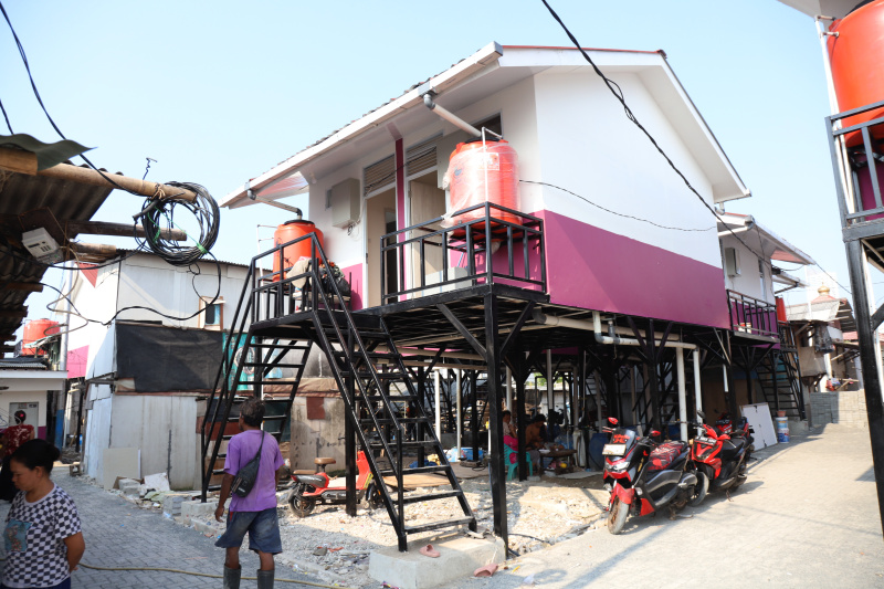 Pekerja sedang menyelesaikan rumah apung dan rumah panggung program dari Kementerian Pertahanan bekerja sama dengan Unhan untuk warga pesisir Muara Angke, Penjaringan untuk mengatasi sering terjadinya abrasi dan banjir rob (Ashar/SinPo.id)