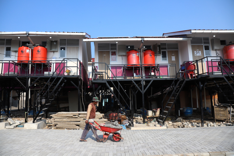 Pekerja sedang menyelesaikan rumah apung dan rumah panggung program dari Kementerian Pertahanan bekerja sama dengan Unhan untuk warga pesisir Muara Angke, Penjaringan untuk mengatasi sering terjadinya abrasi dan banjir rob (Ashar/SinPo.id)