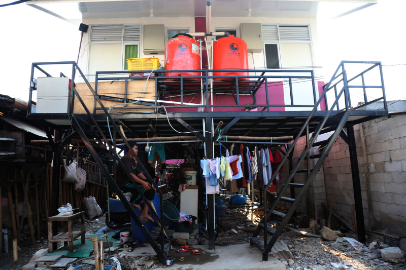 Pekerja sedang menyelesaikan rumah apung dan rumah panggung program dari Kementerian Pertahanan bekerja sama dengan Unhan untuk warga pesisir Muara Angke, Penjaringan untuk mengatasi sering terjadinya abrasi dan banjir rob (Ashar/SinPo.id)