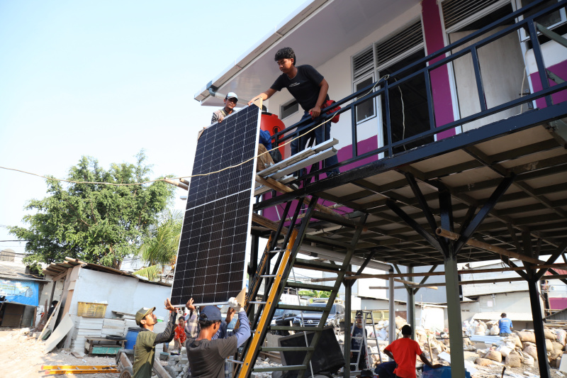 Pekerja sedang menyelesaikan rumah apung dan rumah panggung program dari Kementerian Pertahanan bekerja sama dengan Unhan untuk warga pesisir Muara Angke, Penjaringan untuk mengatasi sering terjadinya abrasi dan banjir rob (Ashar/SinPo.id)