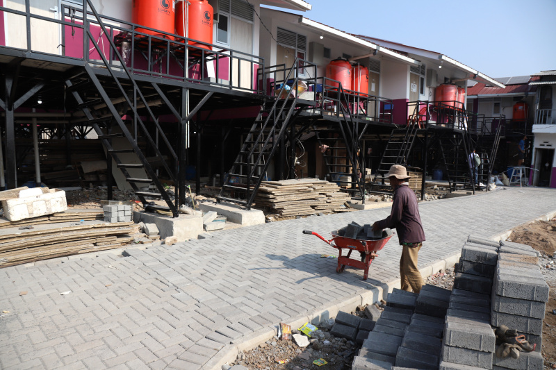 Pekerja sedang menyelesaikan rumah apung dan rumah panggung program dari Kementerian Pertahanan bekerja sama dengan Unhan untuk warga pesisir Muara Angke, Penjaringan untuk mengatasi sering terjadinya abrasi dan banjir rob (Ashar/SinPo.id)